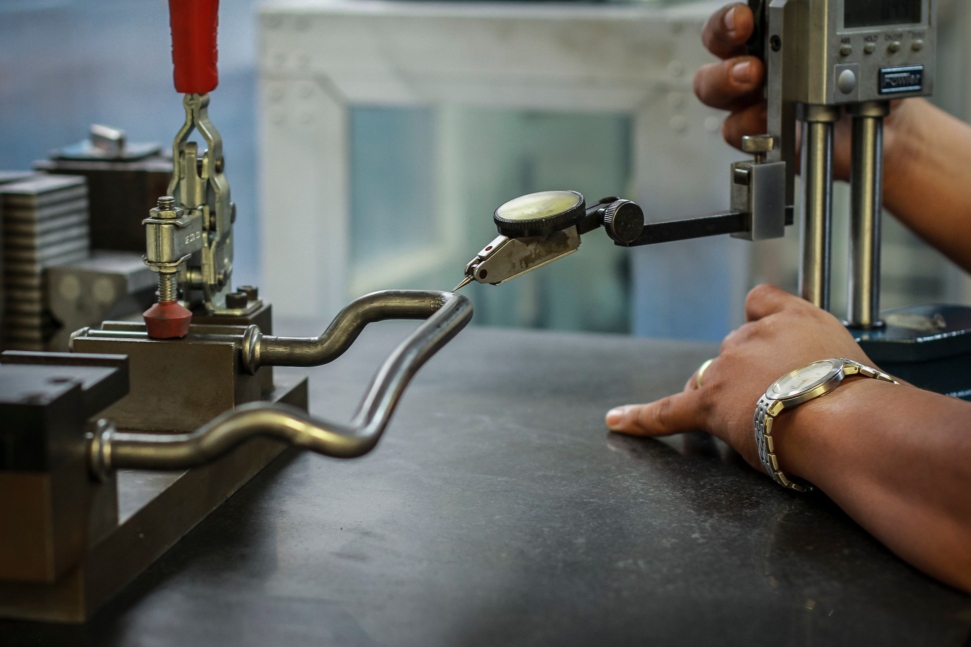Mechanic using a digital caliper for precise measurement of metal component